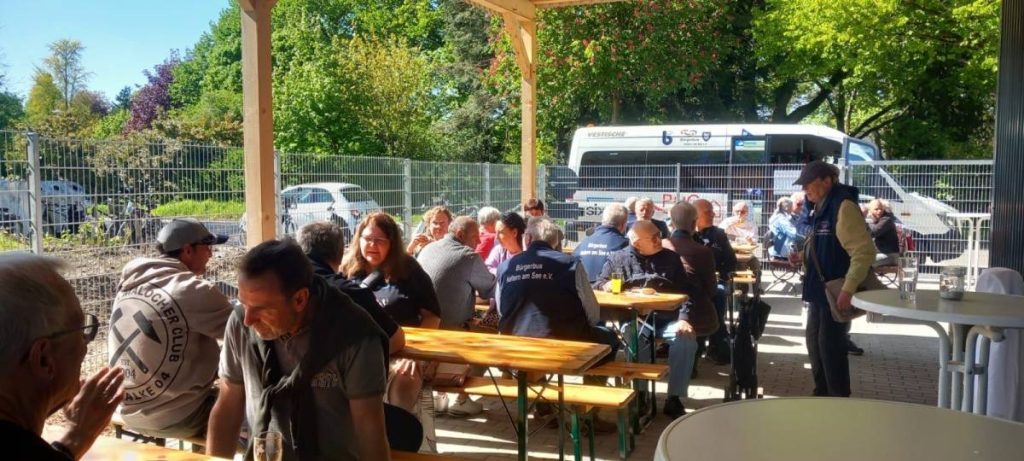 Gäste sitzen bei der Einweihung der Bürgerbusgarage in Haltern zusammen