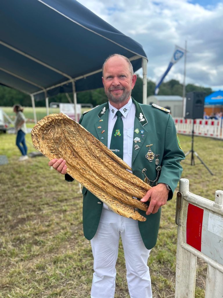 Ein Schütze mit dem rechten Flügel des Vogels beim Schützenfest Hamm-Bossendorf 2026