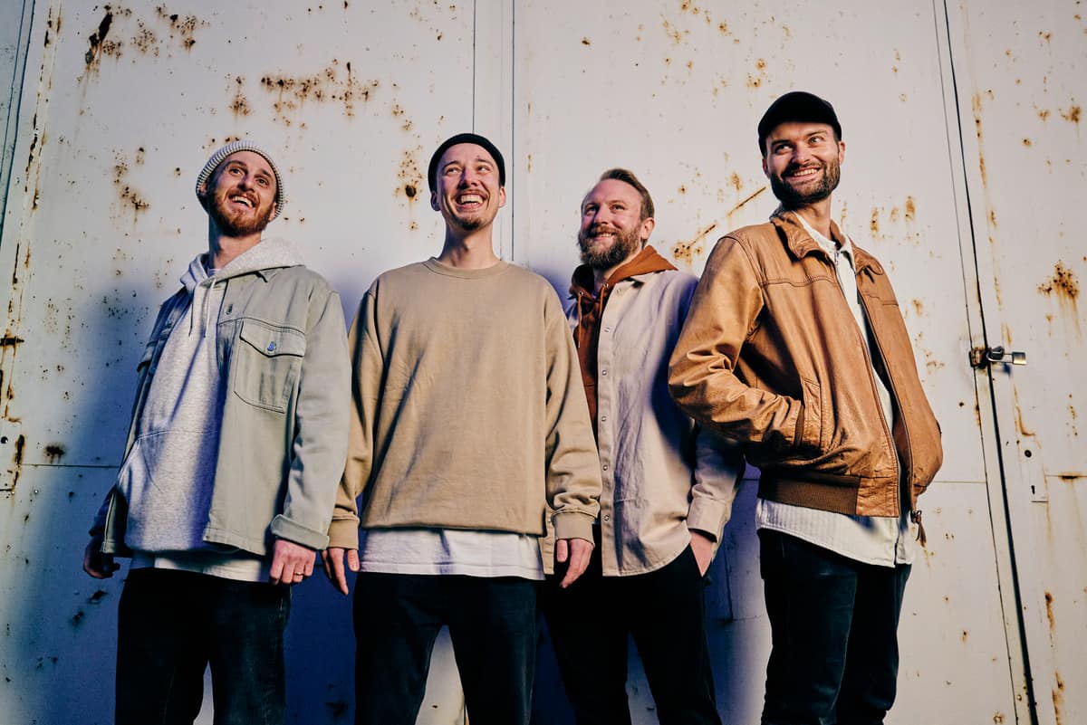 Die vier Musiker der Band Toytoy stehen vor einer hellen Wand