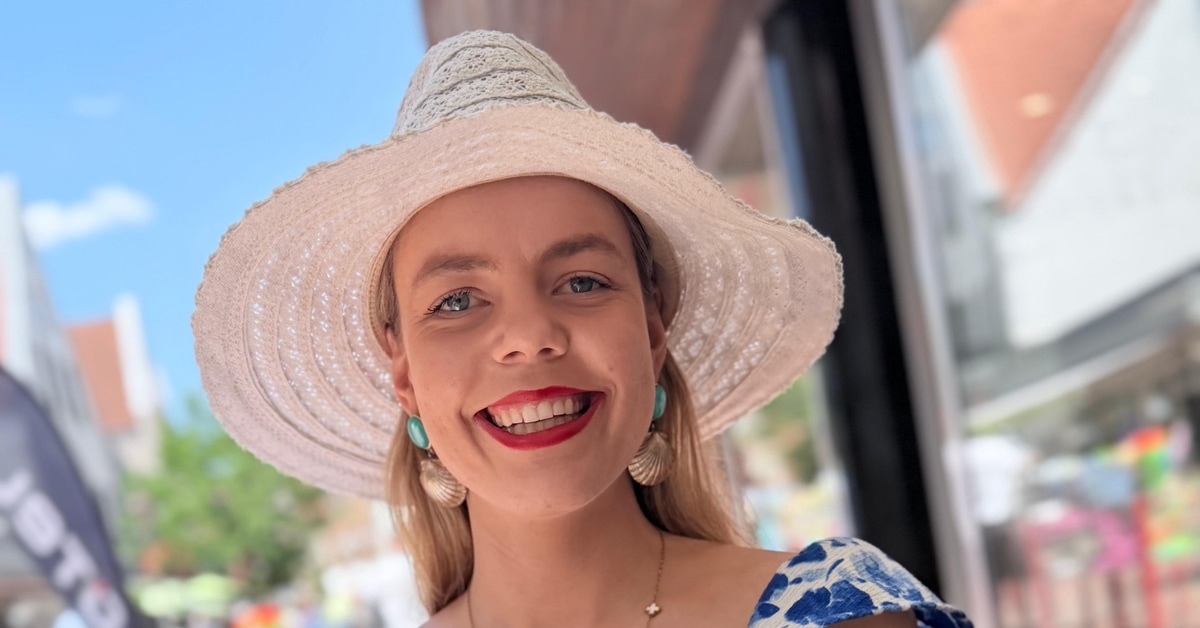 Lara Linka sitzt mit Sommerhut in einem Cafe in Haltern