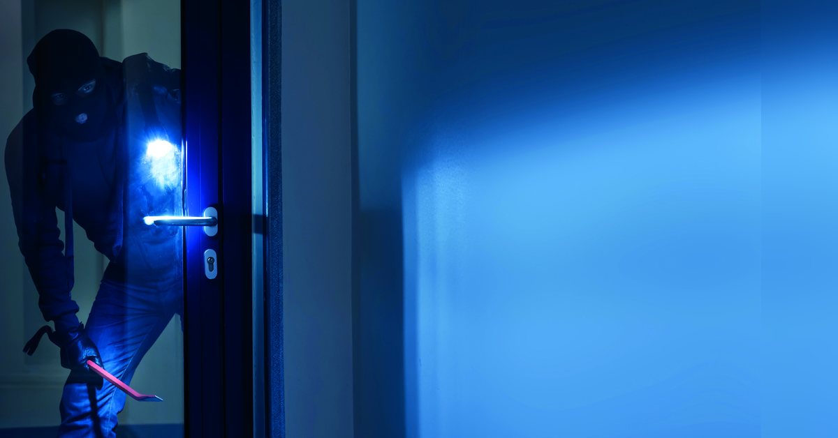 Einbrecher an einer Haustür – ACC Sicherheitstechnik informiert zum Einbruchschutz