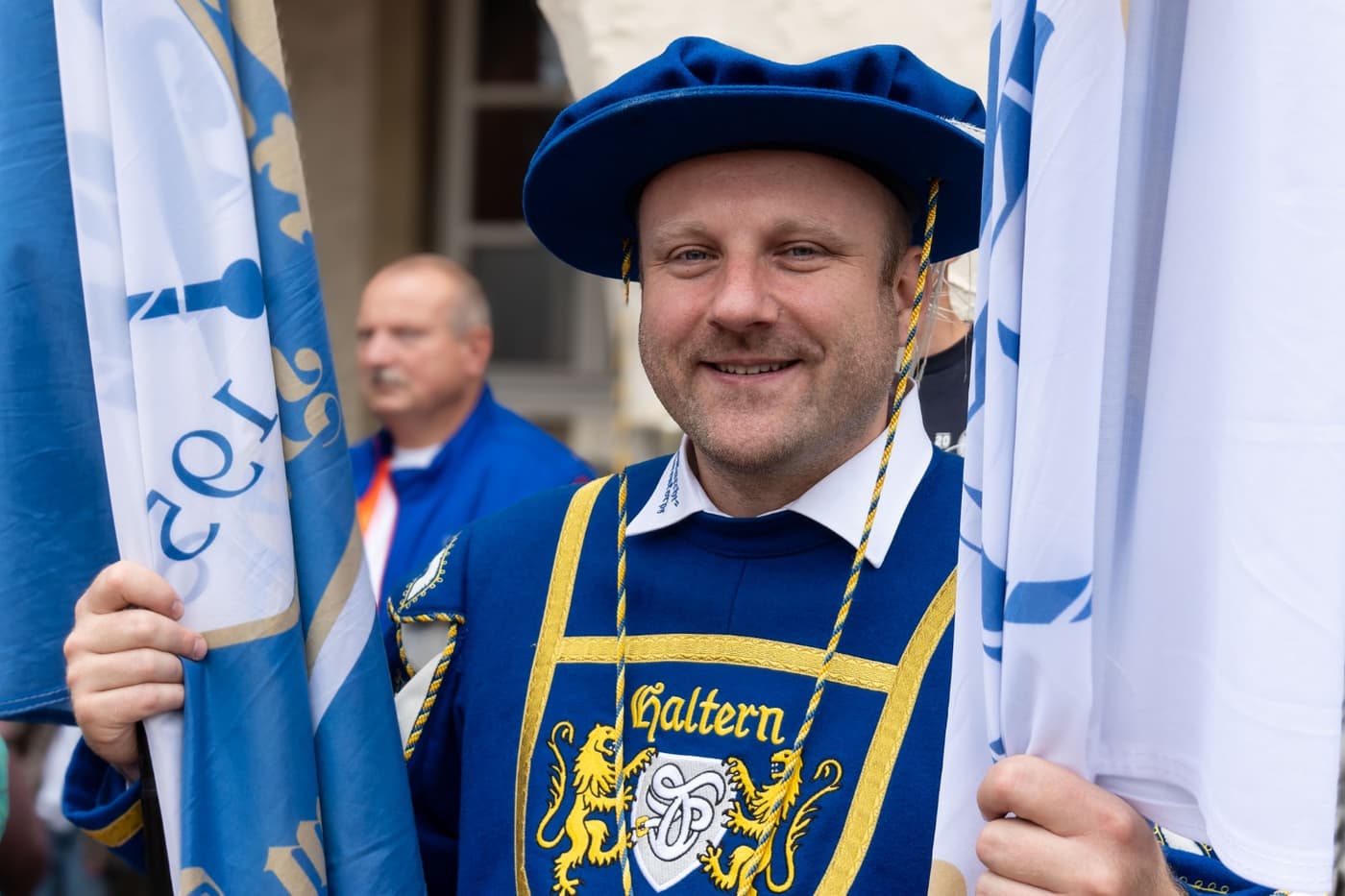 Mitglied der Fanfaren Haltern mit der Vereinsfahne