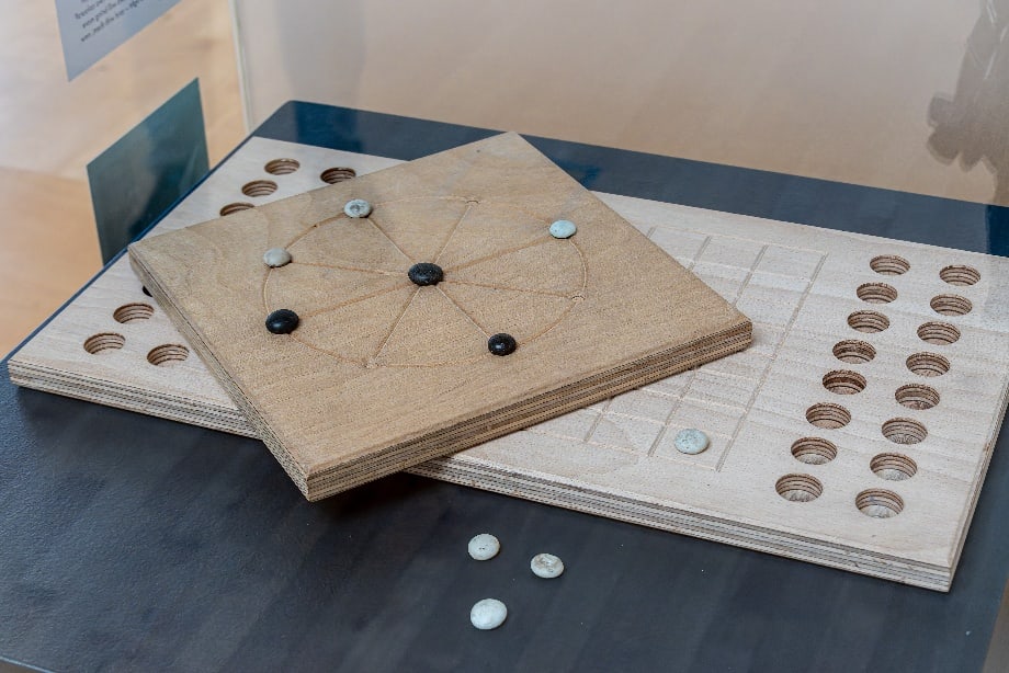 Römische Spielsteine liegen auf einem rekonstruierten Spielbrett