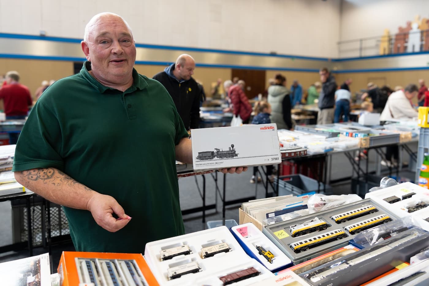 Aussteller hält ein Eisenbahnmodell beim Modellspielzeugmarkt in Haltern