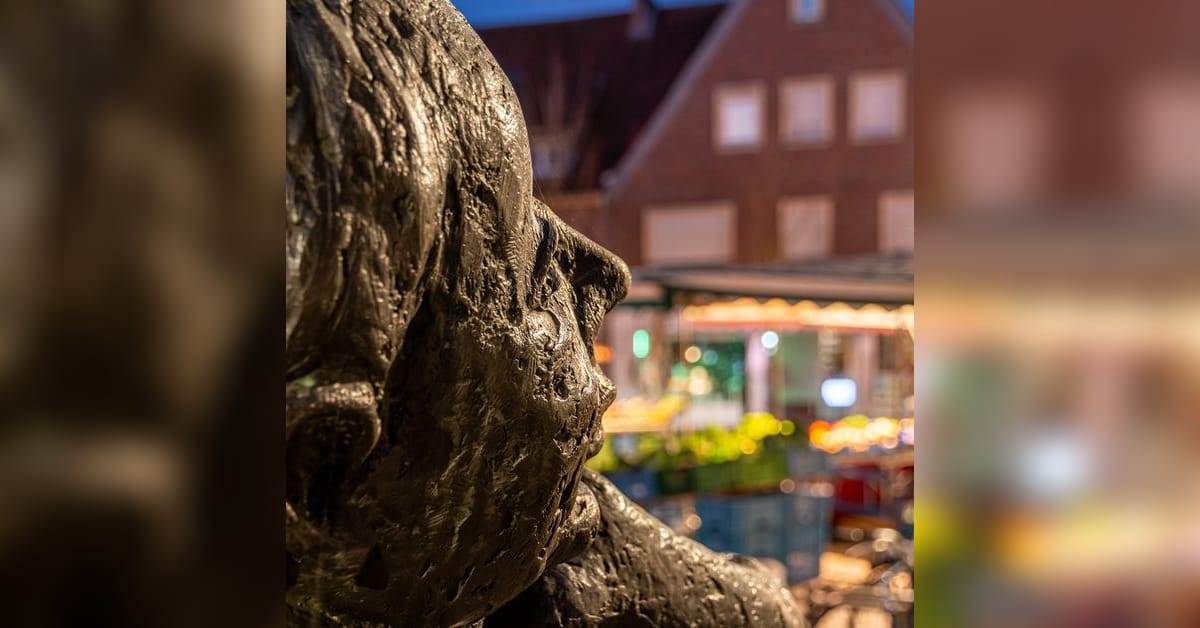Nachtfotografie in Dülmen: beleuchtete Skulptur vor Häusern am Abend