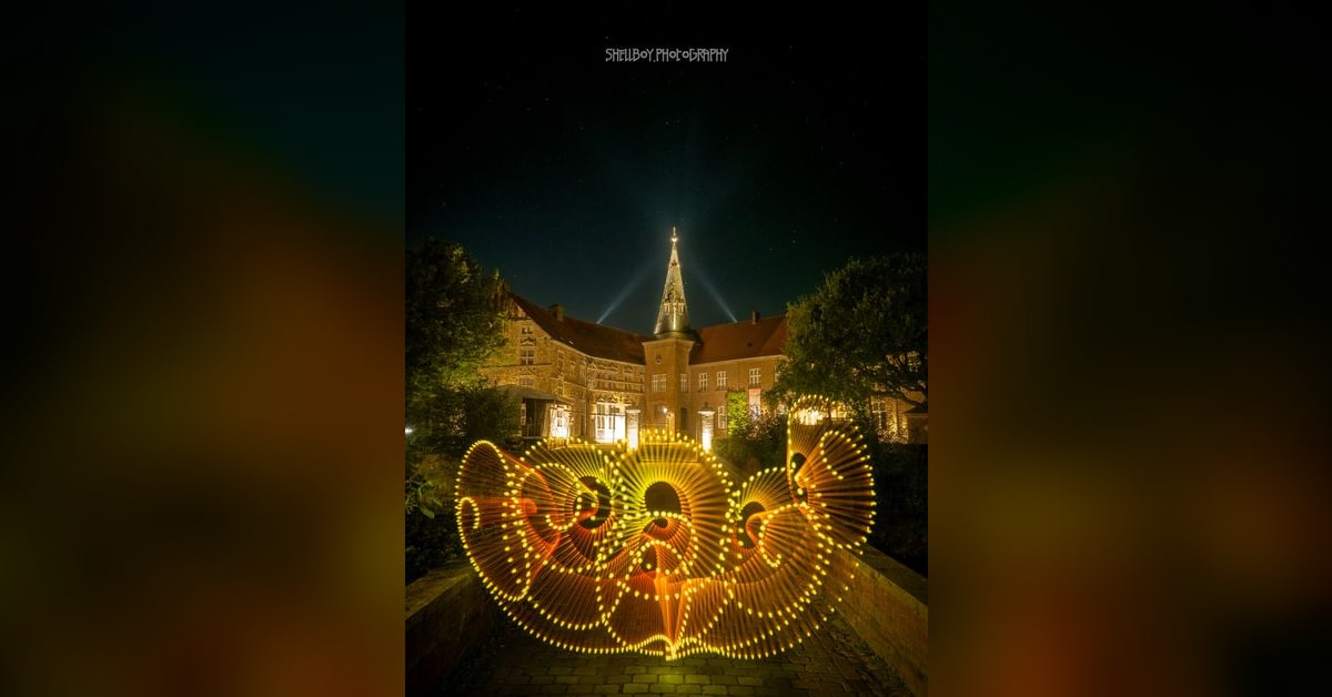 Goldene Lichtmuster vor einem beleuchteten Gebäude als Beispiel für Light Painting